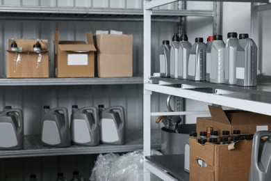 Photo of Containers with motor oils and cardboard boxes in auto store