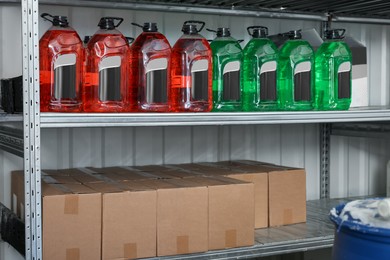 Photo of Different car cleaning products and cardboard boxes in auto store