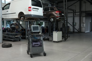 Automobile repair shop with lifted broken cars and diagnostic tools