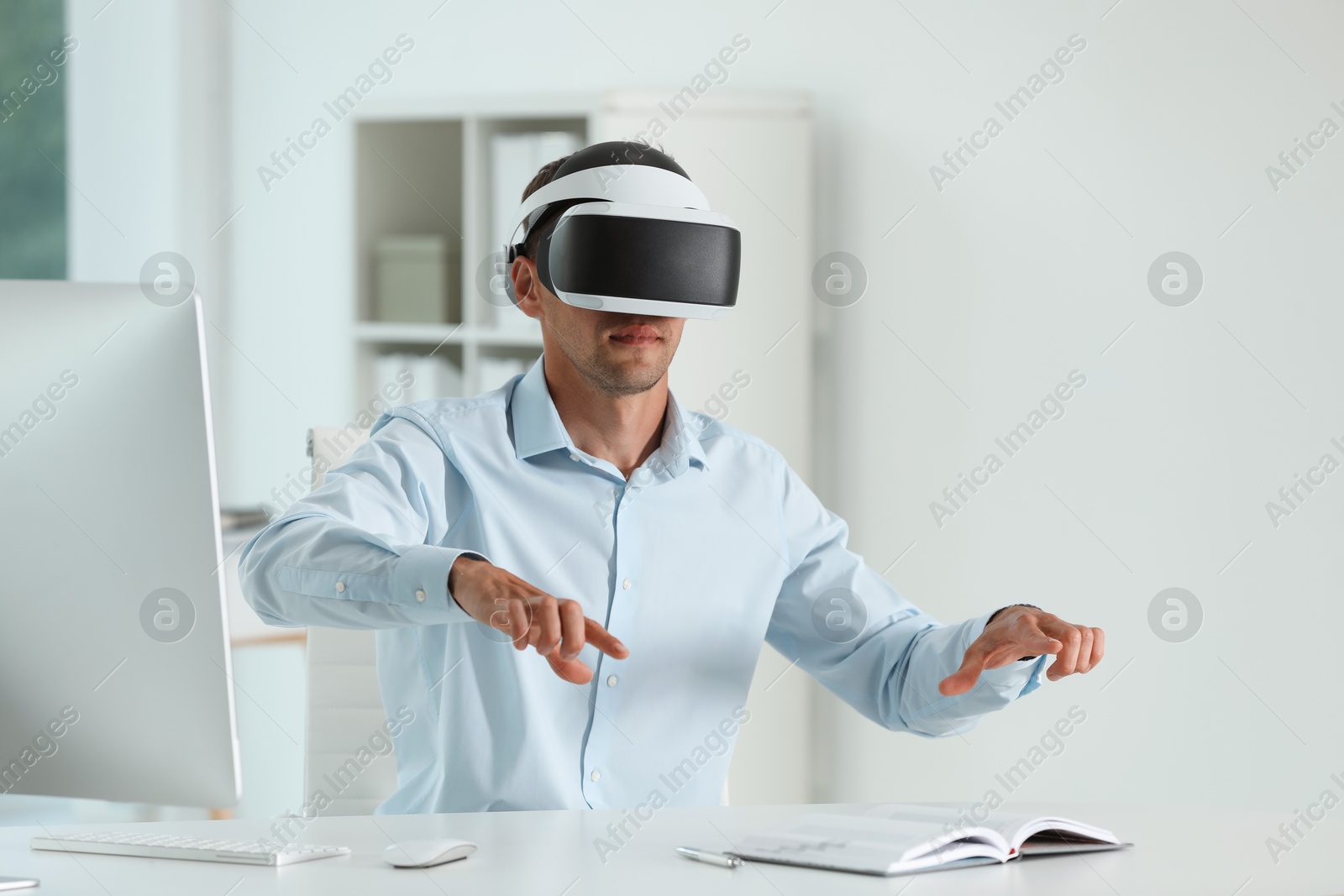 Photo of Man using virtual reality headset in office