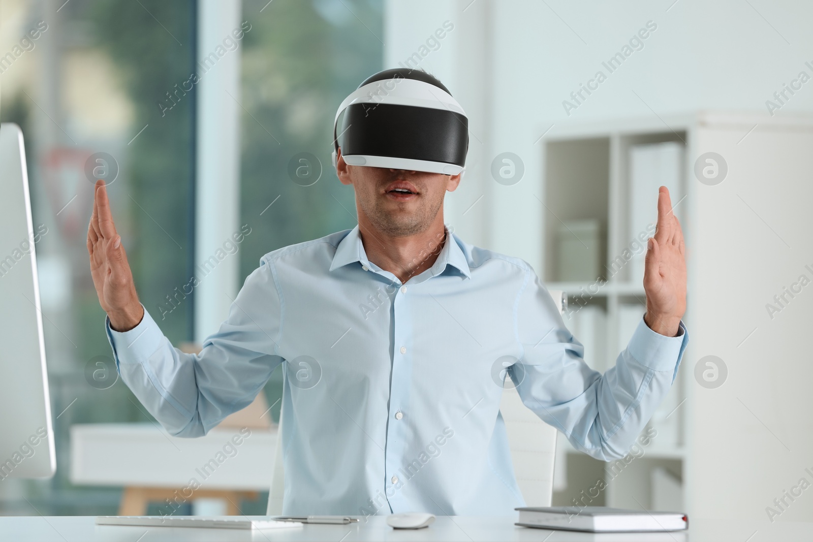 Photo of Man using virtual reality headset in office