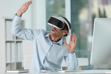 Photo of Man using virtual reality headset in office