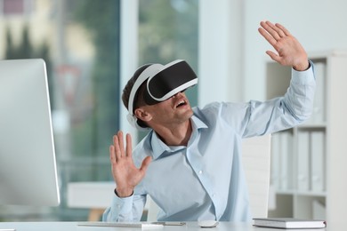 Photo of Man using virtual reality headset in office