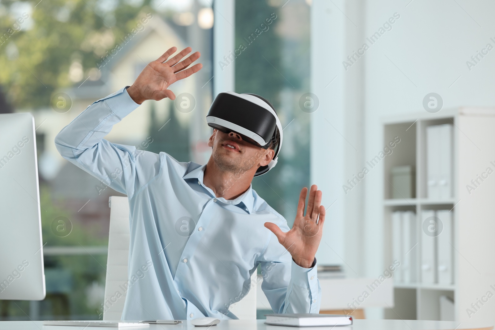 Photo of Man using virtual reality headset in office