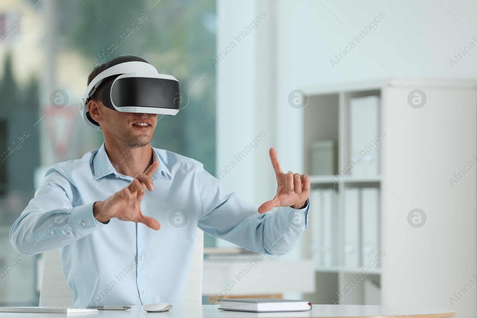 Photo of Man using virtual reality headset in office