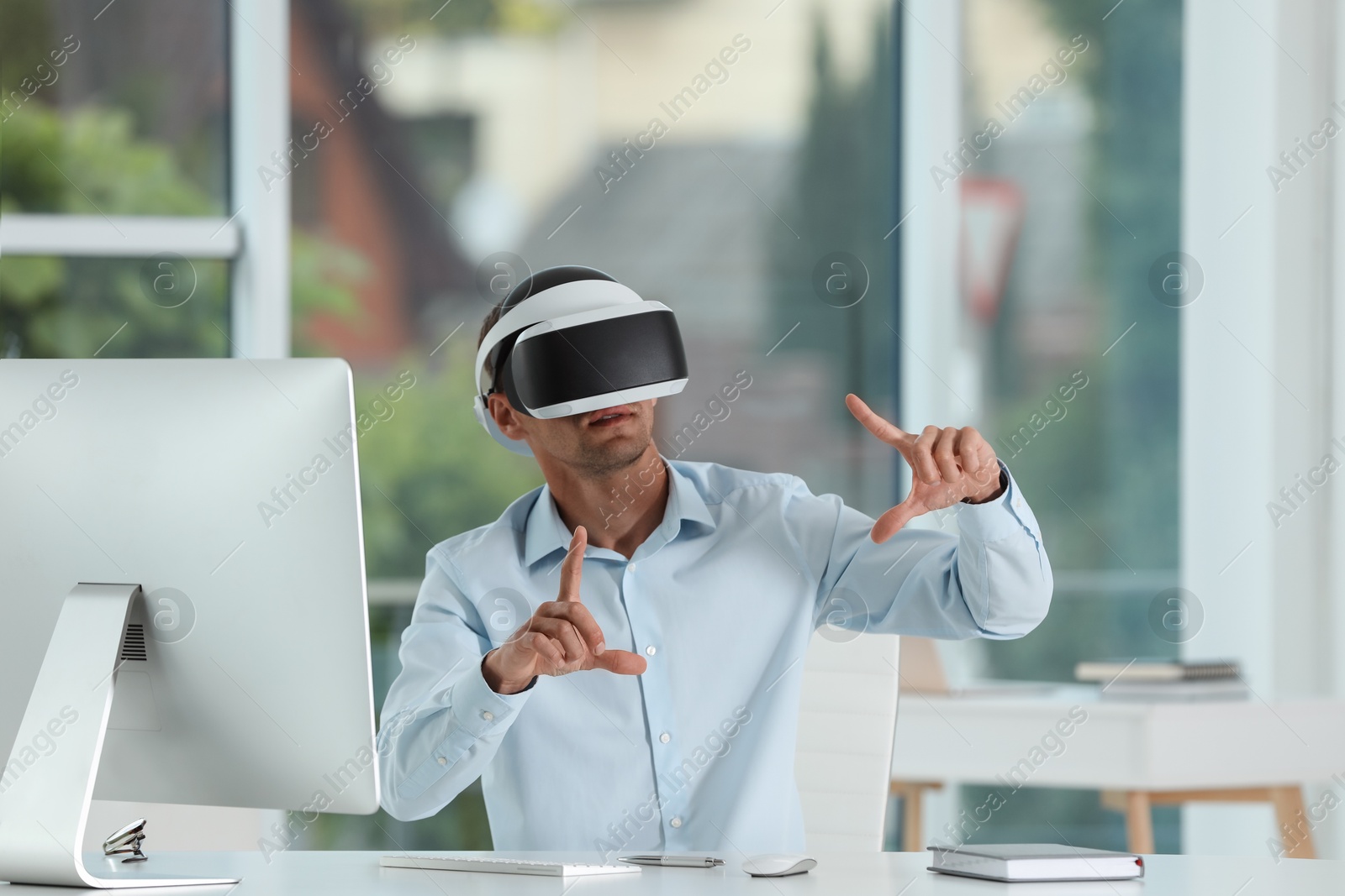 Photo of Man using virtual reality headset in office