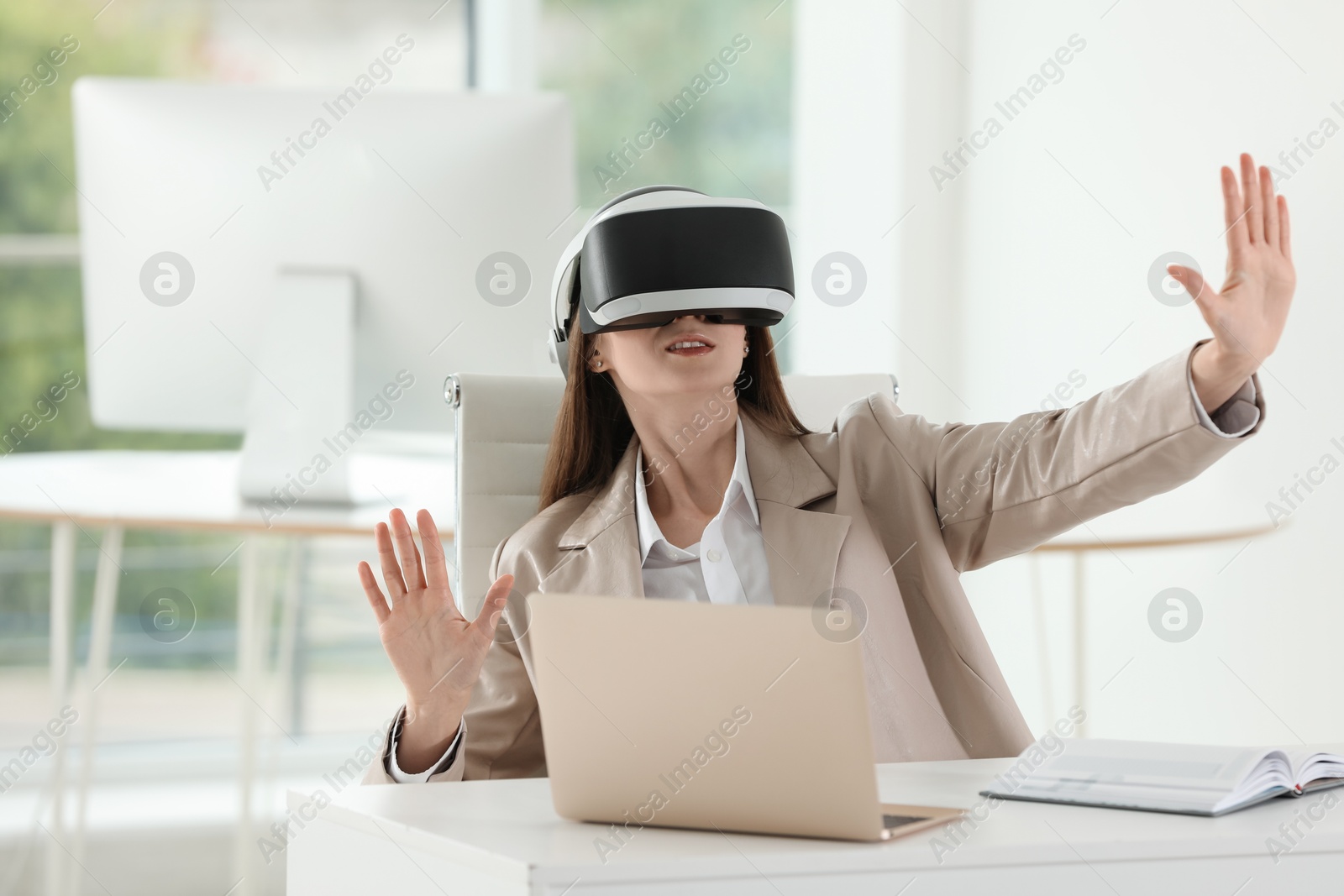 Photo of Woman using virtual reality headset in office