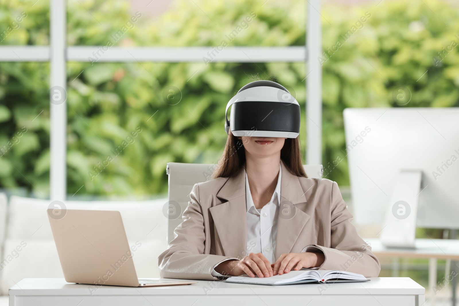 Photo of Woman using virtual reality headset in office