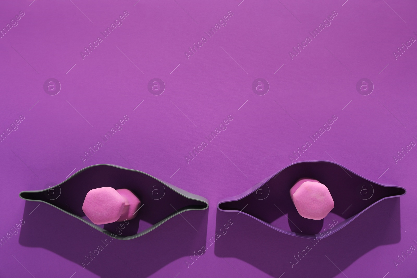 Photo of Dumbbells and fitness elastic bands on purple background, flat lay. Space for text