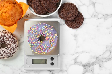 Photo of Flat lay composition of kitchen scale with donut on white marble table. Space for text