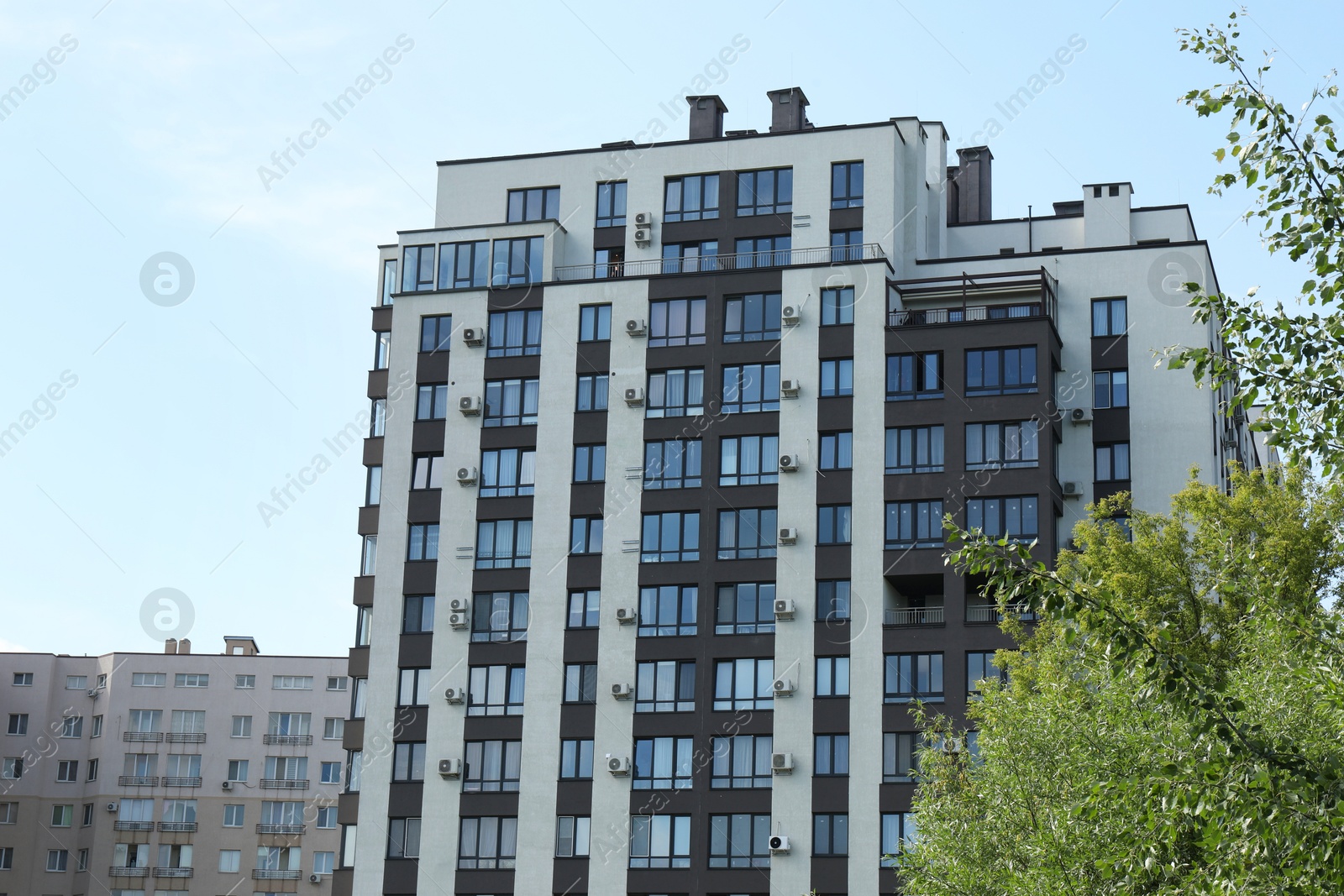 Photo of Modern buildings with big windows against blue sky outdoors