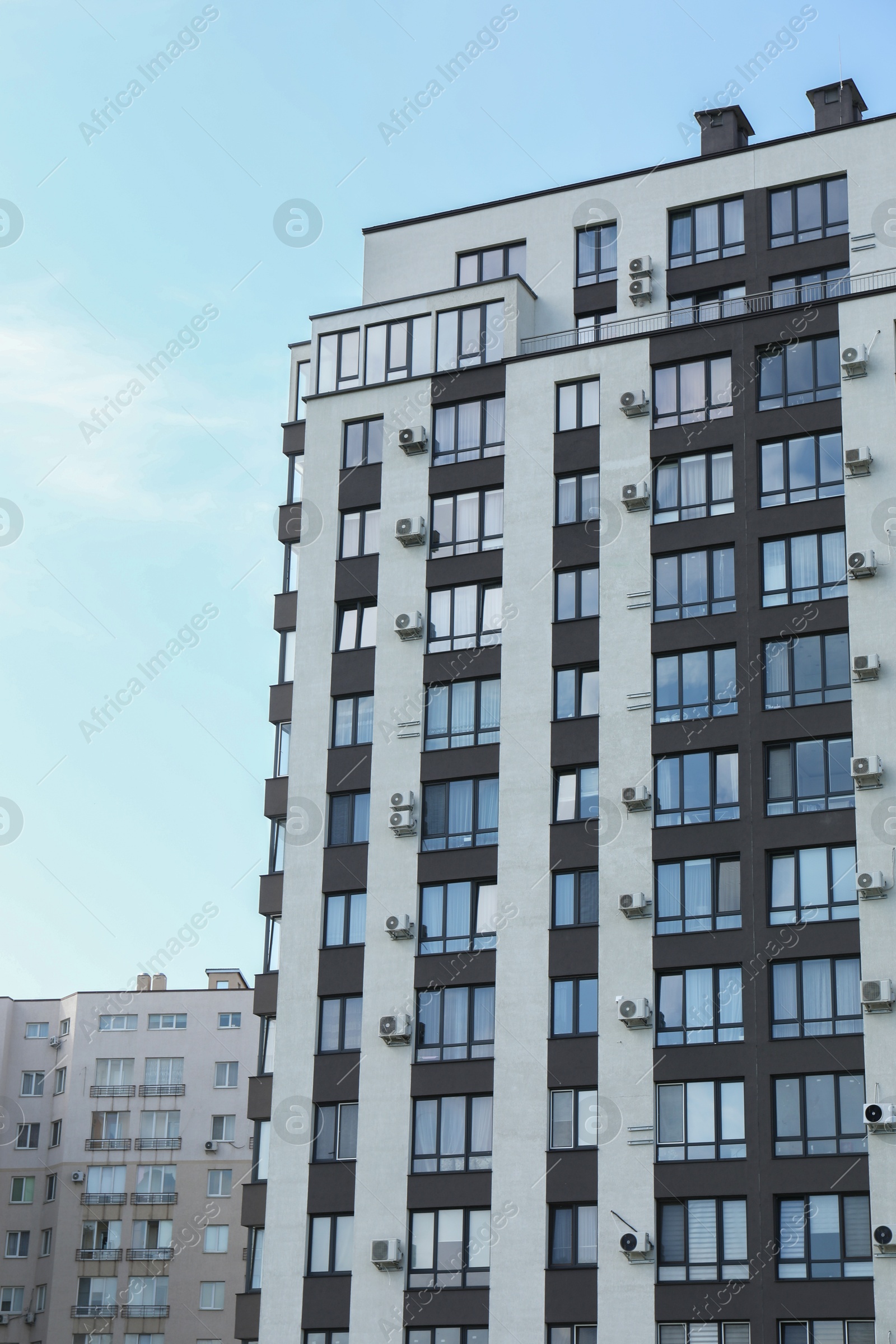 Photo of Modern building with big windows against blue sky outdoors