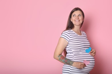 Photo of Beautiful pregnant woman with paper hearts on pink background, space for text. Expecting twins