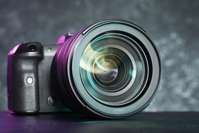 Modern photo camera on black table. Photographer's equipment