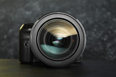 Photo of Modern photo camera on black table. Photographer's equipment