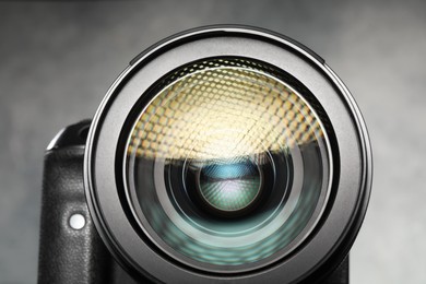 Modern photo camera on grey background, closeup. Photographer's equipment