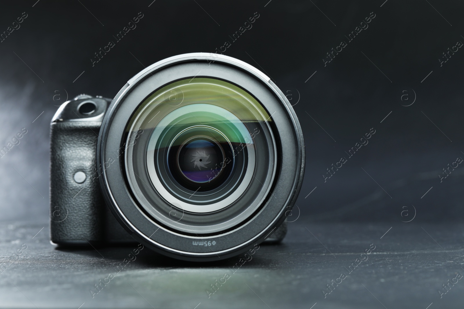 Photo of Modern photo camera on black table, space for text