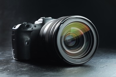 Modern photo camera on black table. Photographer's equipment