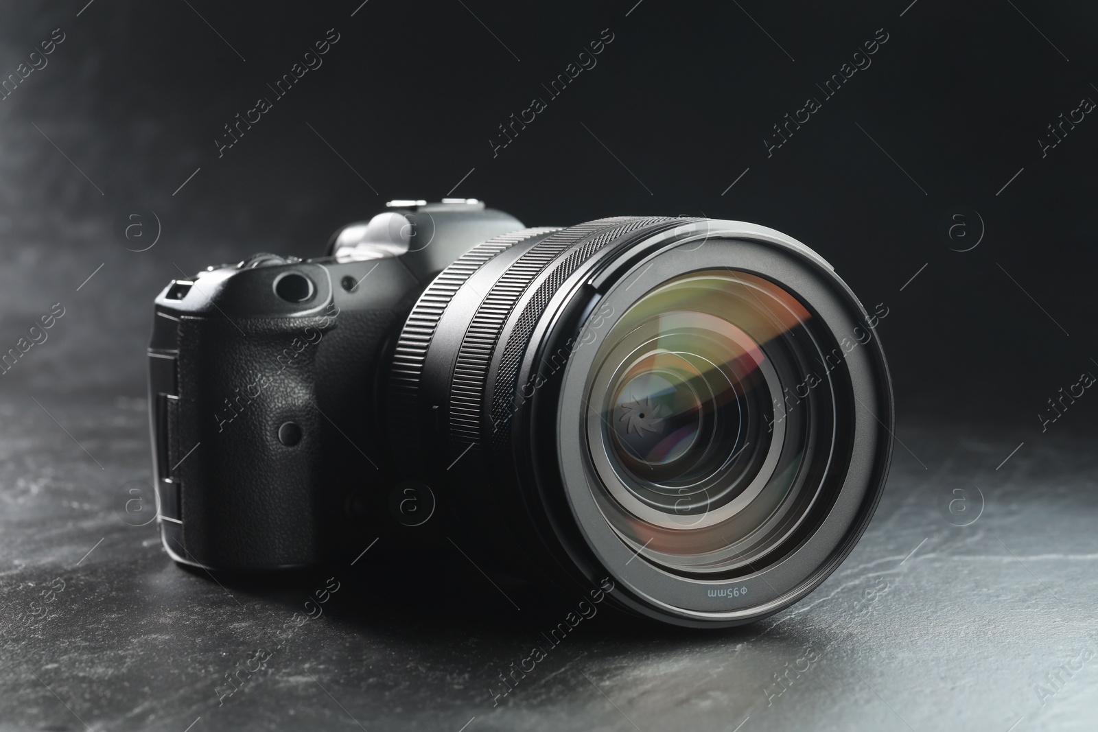 Photo of Modern photo camera on black table. Photographer's equipment