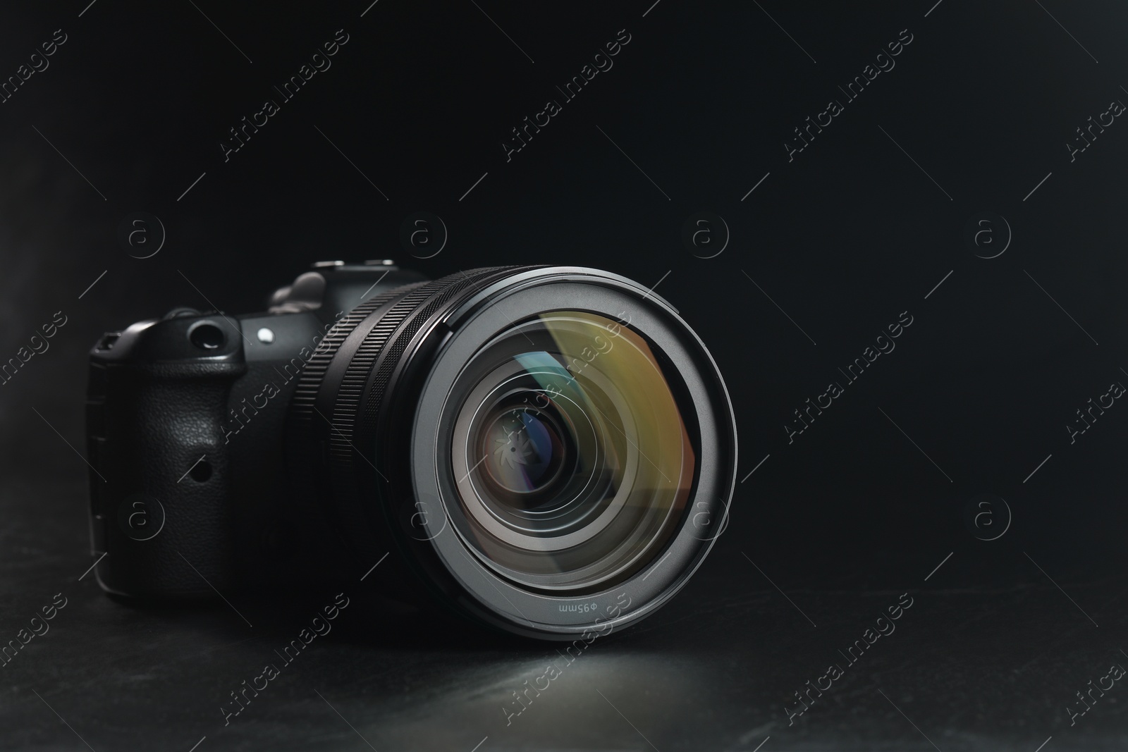 Photo of Modern photo camera on black table, space for text