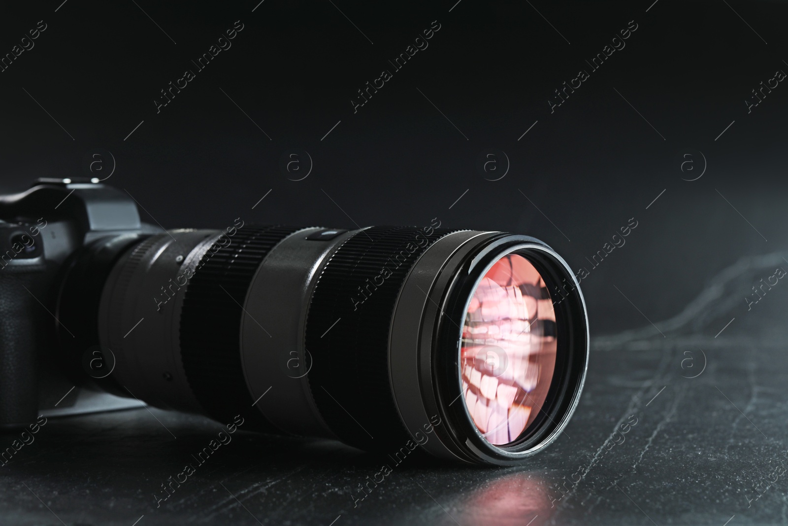 Photo of Modern photo camera on black table. Photographer's equipment