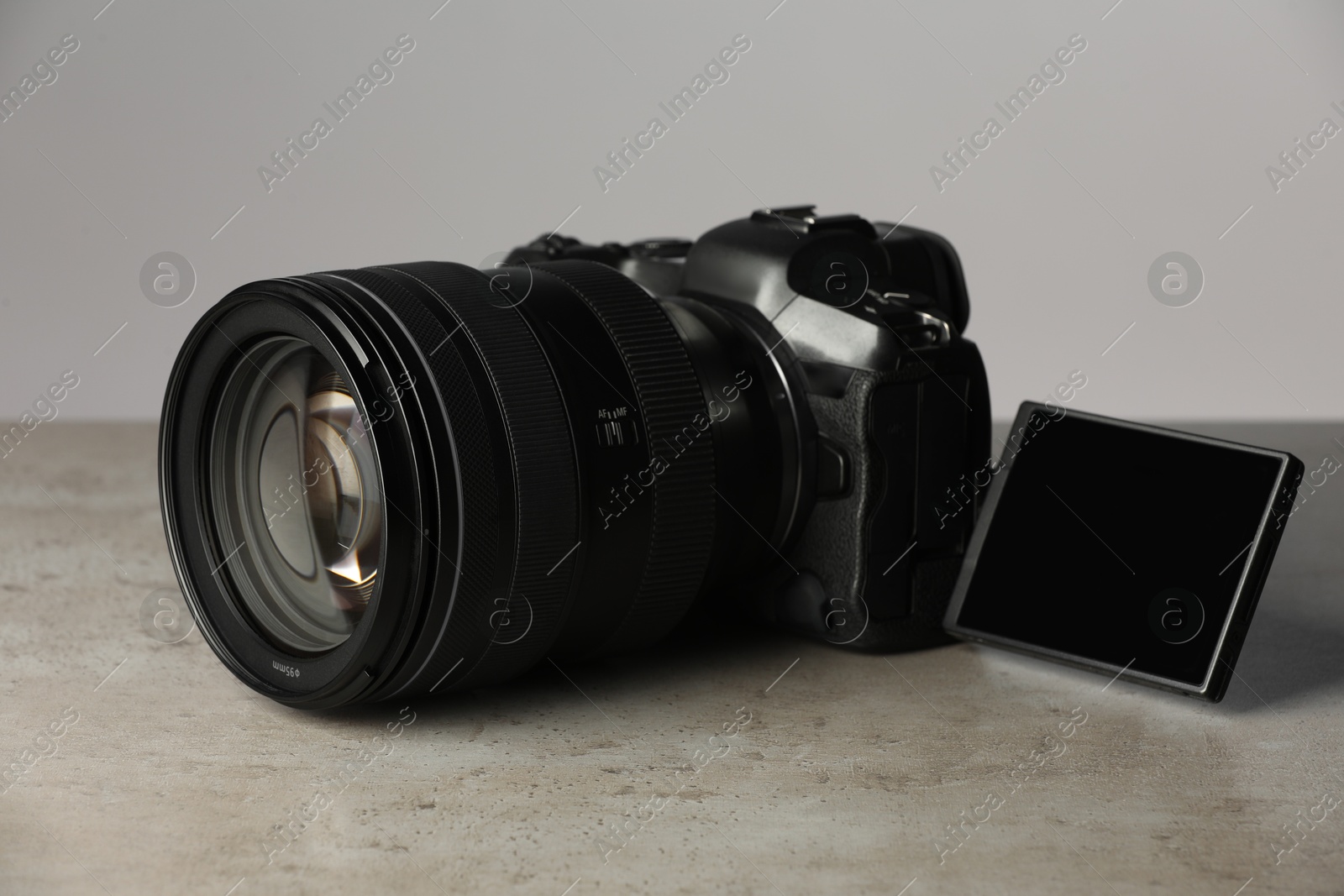 Photo of Modern photo camera on grey table. Photographer's equipment