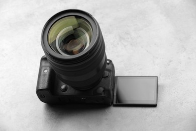 Photo of Modern photo camera on light grey table