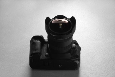 Modern photo camera on light grey table