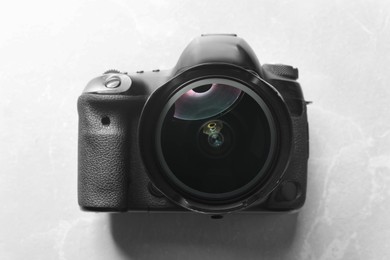 Photo of Modern photo camera on light grey marble table, top view