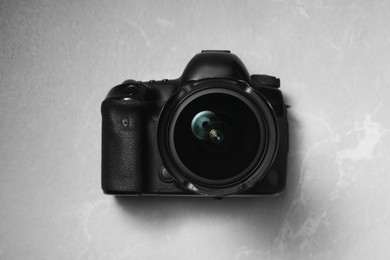 Photo of Modern photo camera on light grey marble table, top view