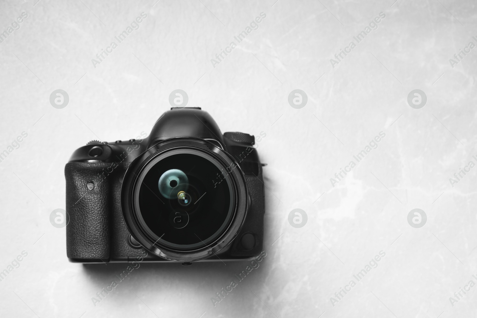 Photo of Modern photo camera on light grey marble table, top view. Space for text