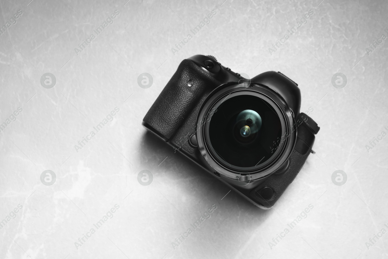 Photo of Modern photo camera on light grey marble table, top view. Space for text