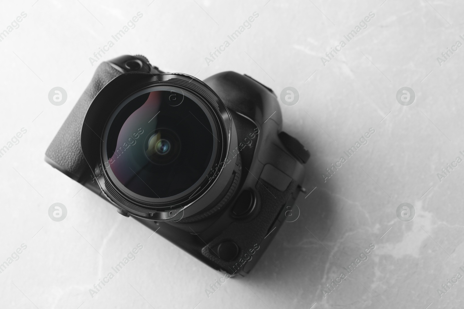 Photo of Modern photo camera on light grey marble table, above view. Space for text