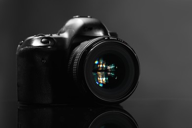 Photo of One modern photo camera on mirror surface