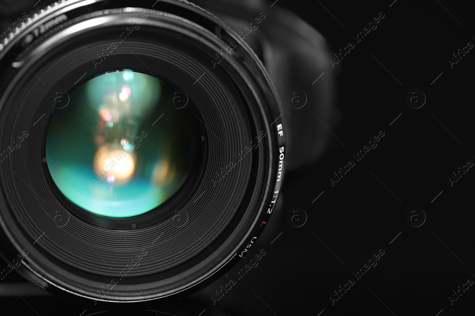 Photo of One modern photo camera on black background, closeup. Space for text