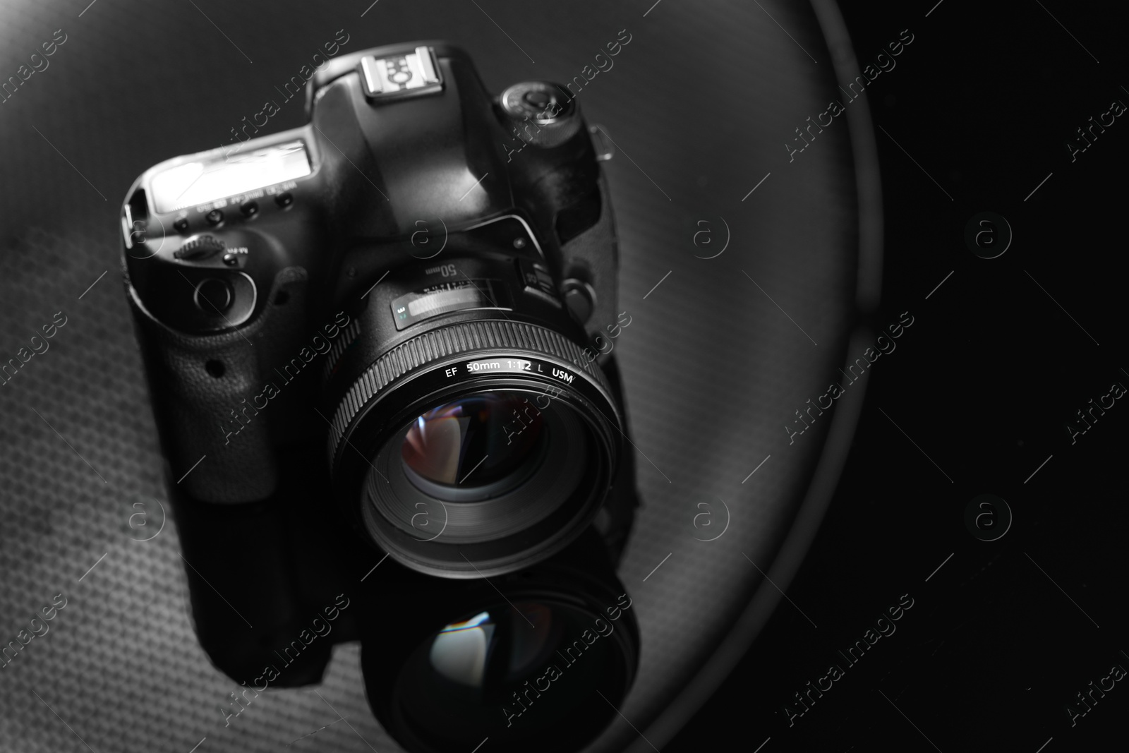 Photo of One modern photo camera on mirror surface, space for text