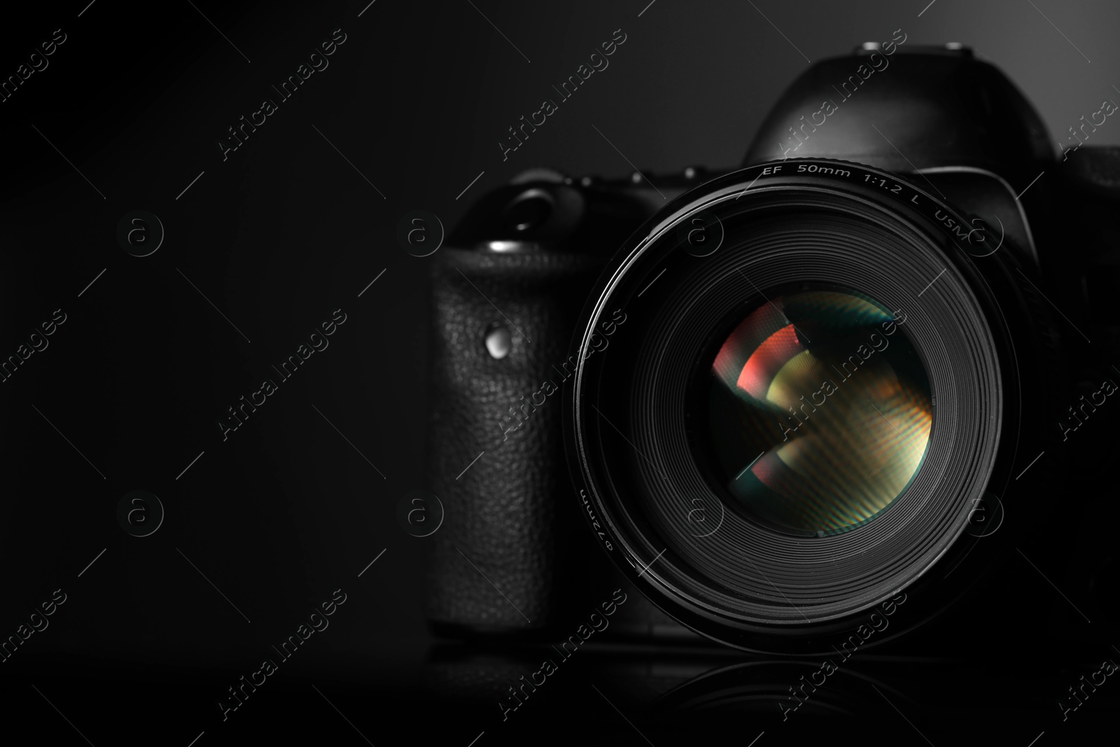 Photo of One modern photo camera on black background, space for text