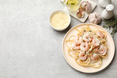 Photo of Delicious pasta with shrimps served on grey table, flat lay. Space for text