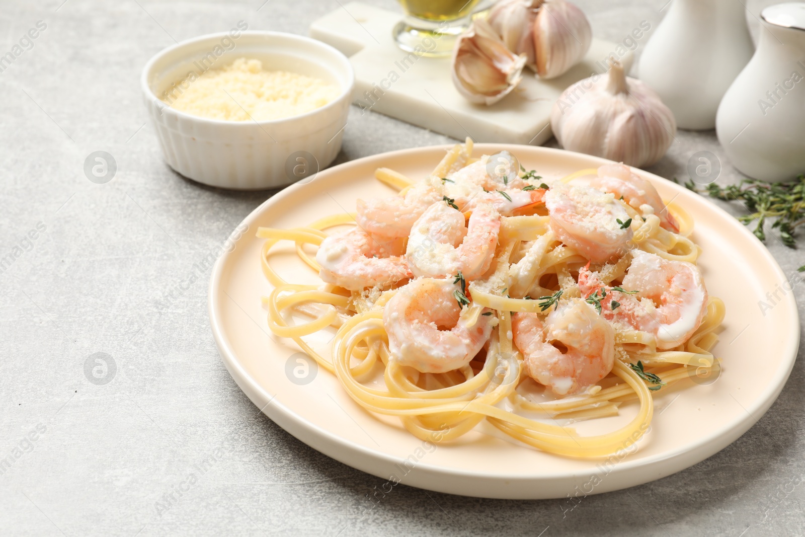 Photo of Delicious pasta with shrimps served on grey table, closeup