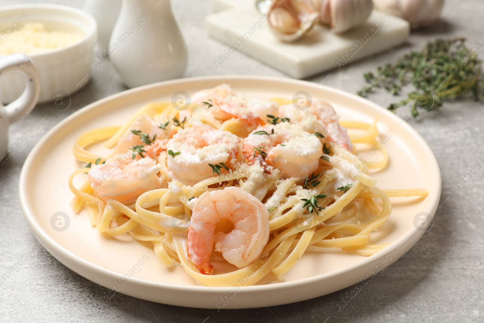 Photo of Delicious pasta with shrimps served on grey table, closeup