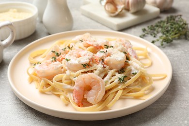 Photo of Delicious pasta with shrimps served on grey table, closeup