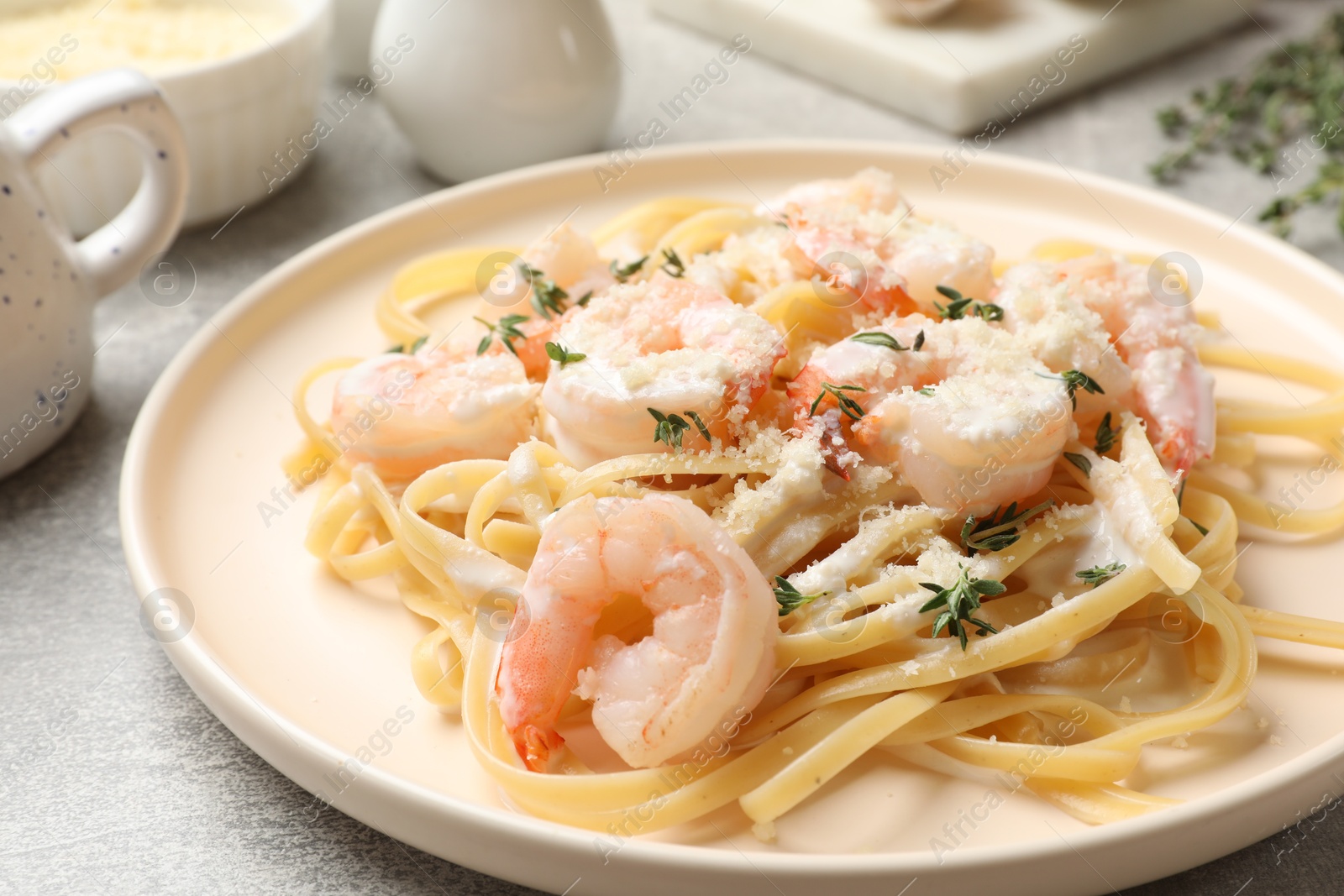 Photo of Delicious pasta with shrimps served on grey table, closeup