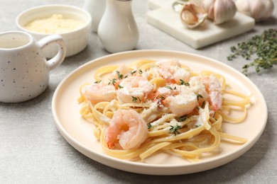 Photo of Delicious pasta with shrimps served on grey table, closeup