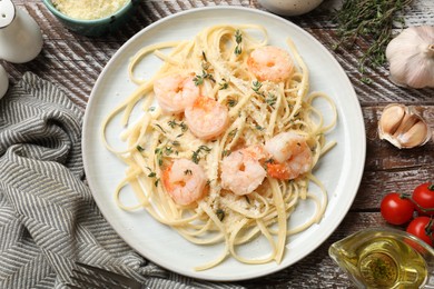 Photo of Delicious pasta with shrimps and products on wooden table, flat lay