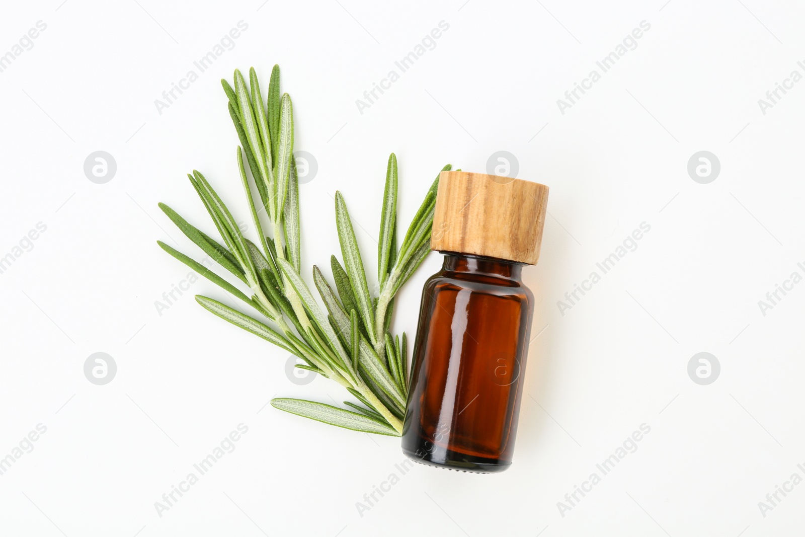 Photo of Bottle of essential oil and fresh rosemary on white background, flat lay