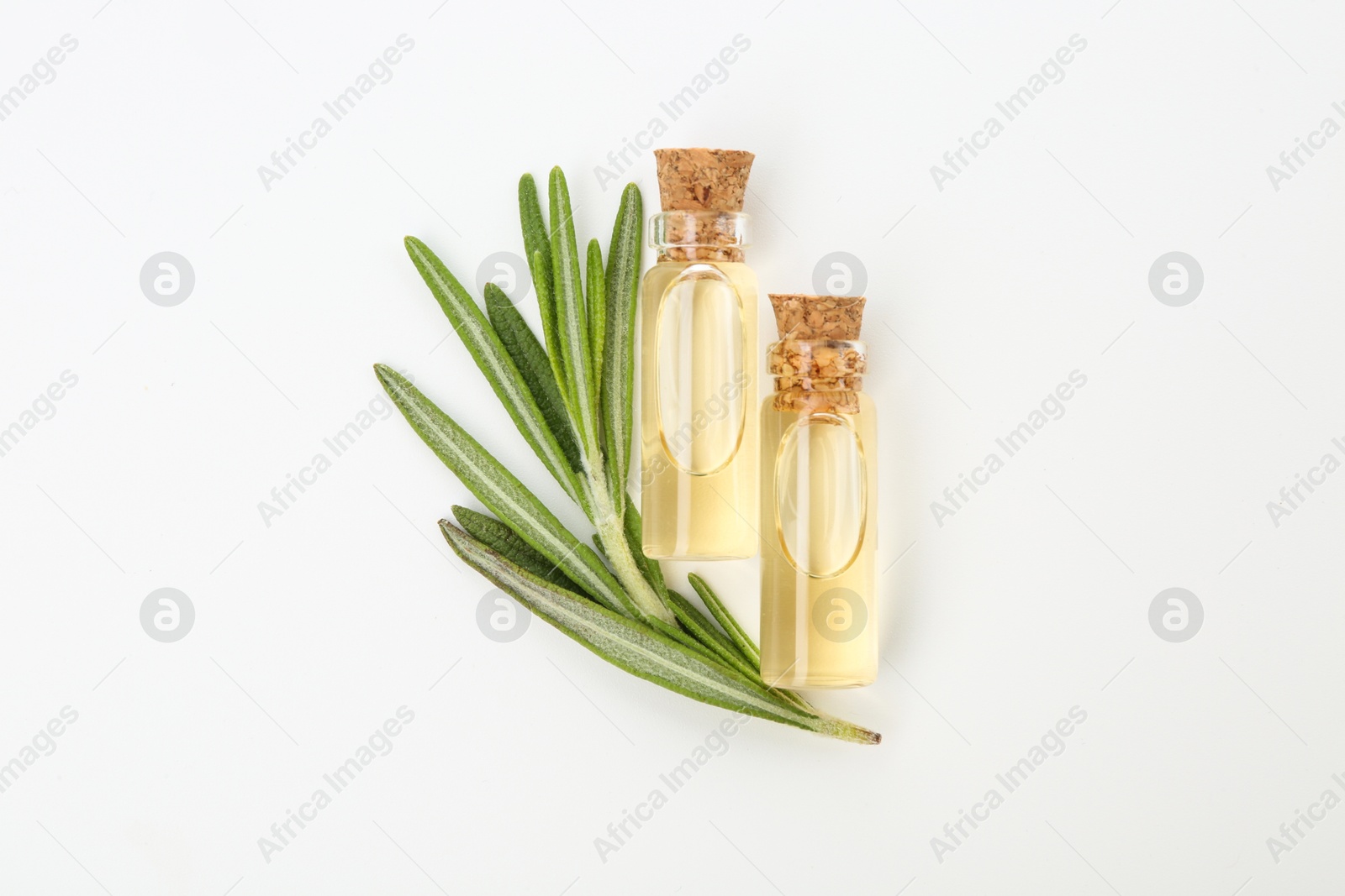 Photo of Bottles of essential oil and fresh rosemary on white background, flat lay