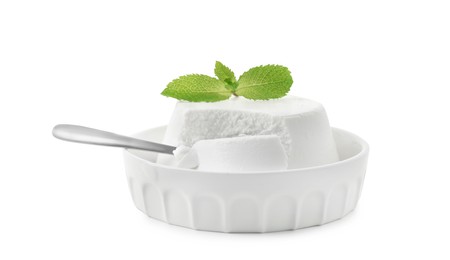 Photo of Delicious ricotta cheese, mint and spoon in bowl isolated on white