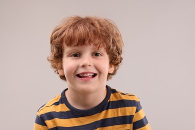 Photo of Portrait of cute little boy on grey background