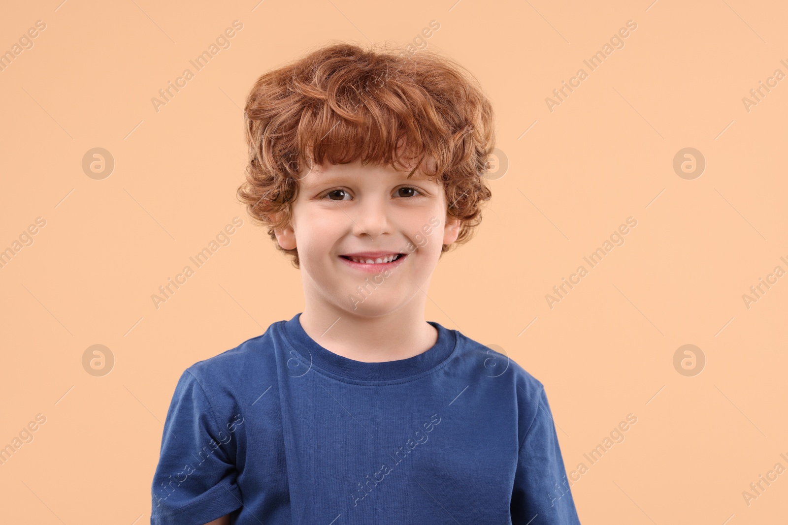 Photo of Portrait of cute little boy on beige background