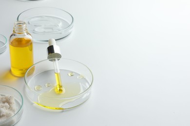 Petri dishes with different cosmetic products on white background. Space for text